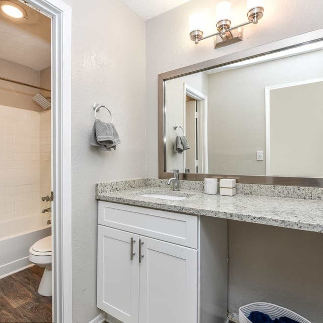 The Preserve at Dunwoody - Bathroom With White Cabinets and Granite Countertops